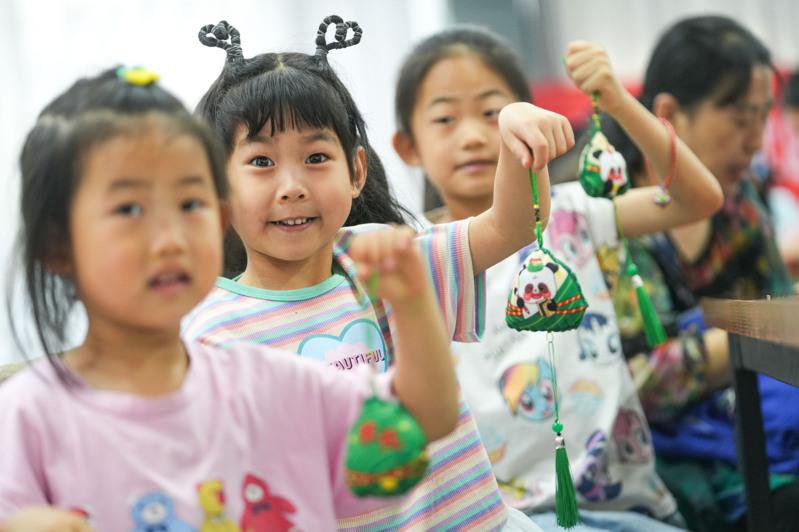 6月8日，山东省邹平市黄山街道月河社区的孩子展示自己制作的端午香囊。 （新华社）