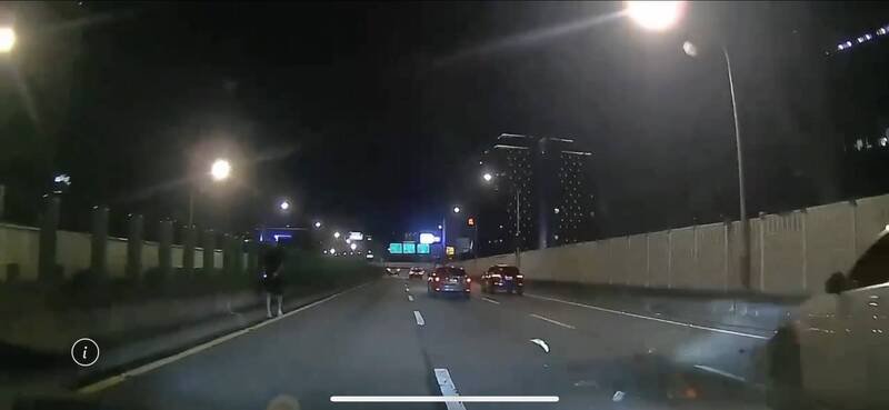 杨男下车徒步于高架道路,欲捡拾掉落物,险象环生。(记者邱俊福翻摄) 杨男下车徒步于高架道路,欲捡拾掉落物,险象环生。(记者邱俊福翻摄)