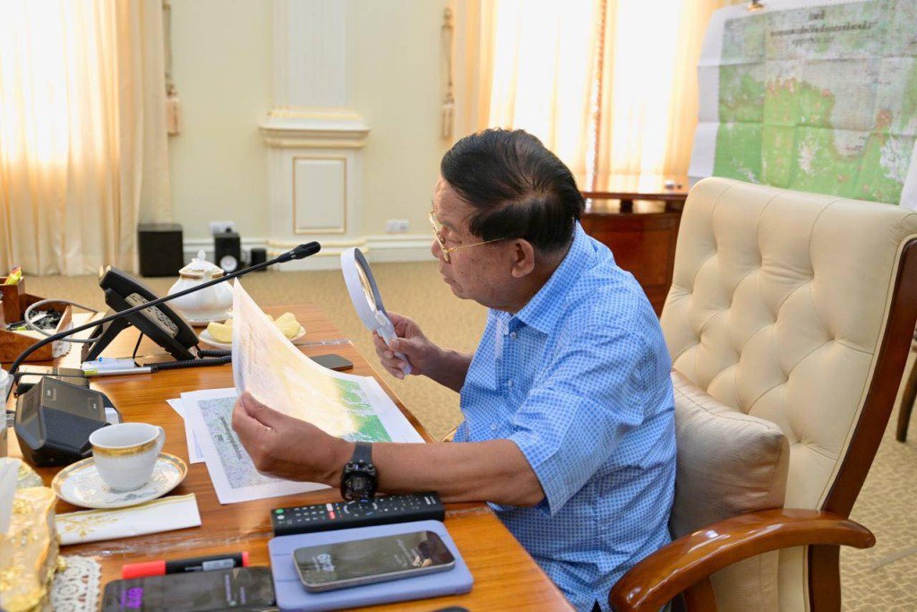 洪森拿起放大镜仔细端详地图。 Samdech Hun Sen of Cambodia