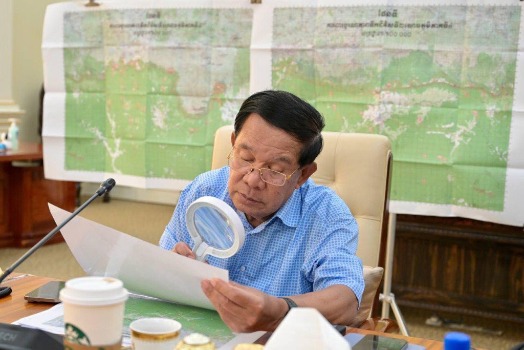 洪森拿起放大镜仔细端详地图。 Samdech Hun Sen of Cambodia
