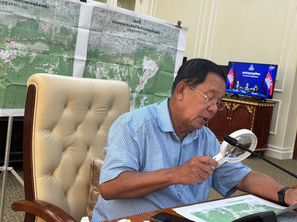 洪森拿起放大镜仔细端详地图。 Samdech Hun Sen of Cambodia