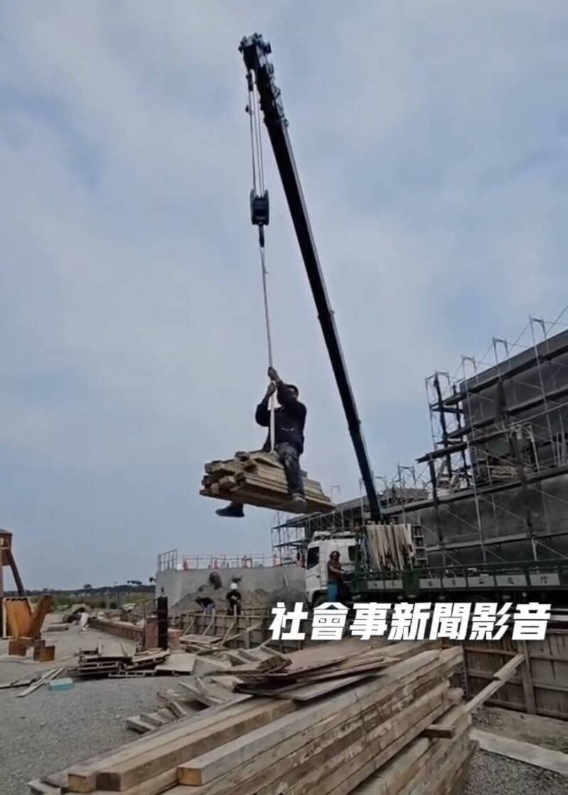 工人坐在模板上随吊车垂降到地面，过程中还如牛仔驯马般前后摇晃嬉戏。（取自「社会事新闻影音」）