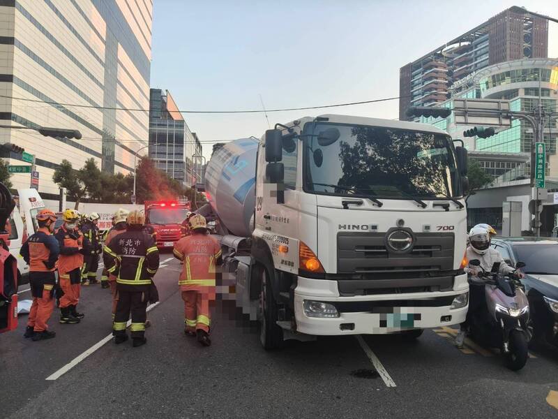 女骑士遭卷入水泥预拌车底受困，大批消防人员到场救援。（记者陆运锋翻摄）