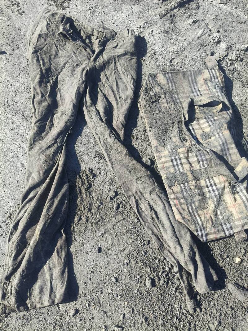 现场挖到的包包和裤子，家属认为就是父母亲穿过用过的物品。（民众提供）