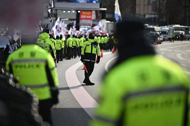 当地时间2025年1月3日，韩国首尔，警方在前总统尹锡悦的住所附近监控支持者。图片来源：视觉中国