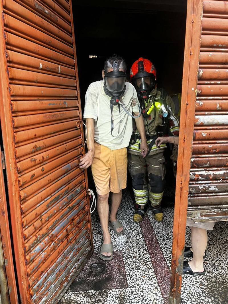 屏市民宅发生火警，消防人员将受困者救出。（屏县消防局提供）