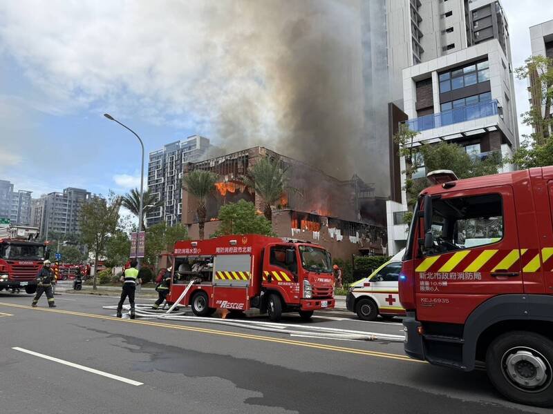 新北市新店央北重划区一处建案样品屋起火燃烧，大批消防人员到场灌救。（记者陆运锋翻摄）