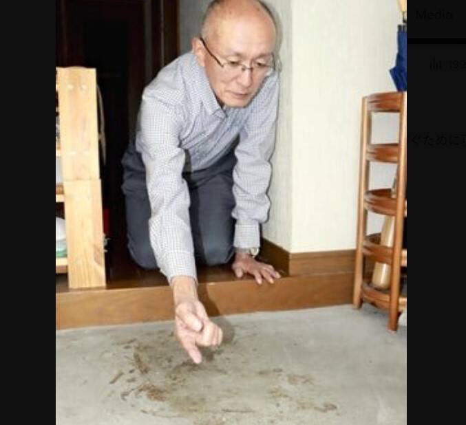 日本爱知县名古屋主妇1999年11月在住处遭到杀害，丈夫高羽悟26年来花了超过2000万日圆租下房屋保留现场。图为高羽悟指著屋内血迹。（图撷自@ROD_88_「X」帐号）