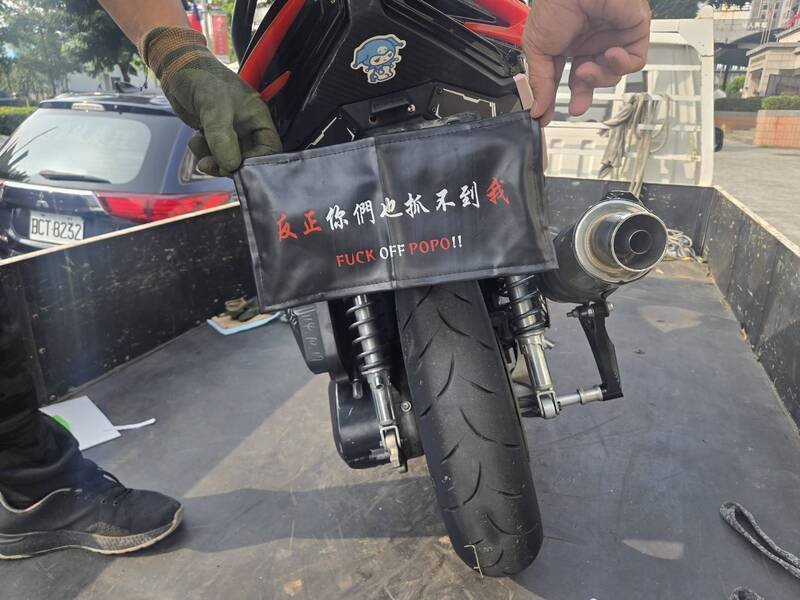 置物箱内还有1块印著「反正你们也抓不到我 FXXK OFF POPO!!」的车牌套。（民众提供）