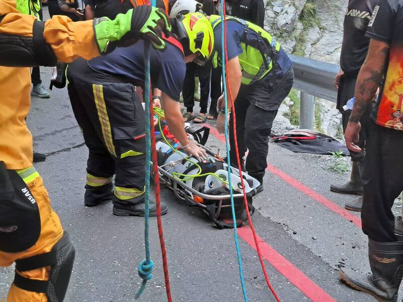 消防、搜救人员垂降到山谷后将工人吊挂上来。（民众提供）