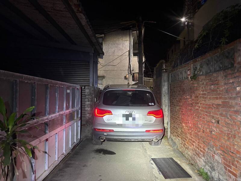 奥迪休旅车「头过身没过」卡窄巷，驾驶弃车逃逸。（记者彭健礼翻摄）