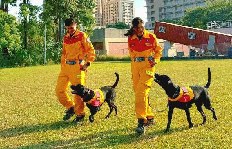 领犬员小队长罗竹君（右）与搜救犬Clint（克林）、队员温堤钧（左）与搜救犬Candice（坎蒂斯）目前已通过IRO国际A级认证。（记者吴升儒翻摄）