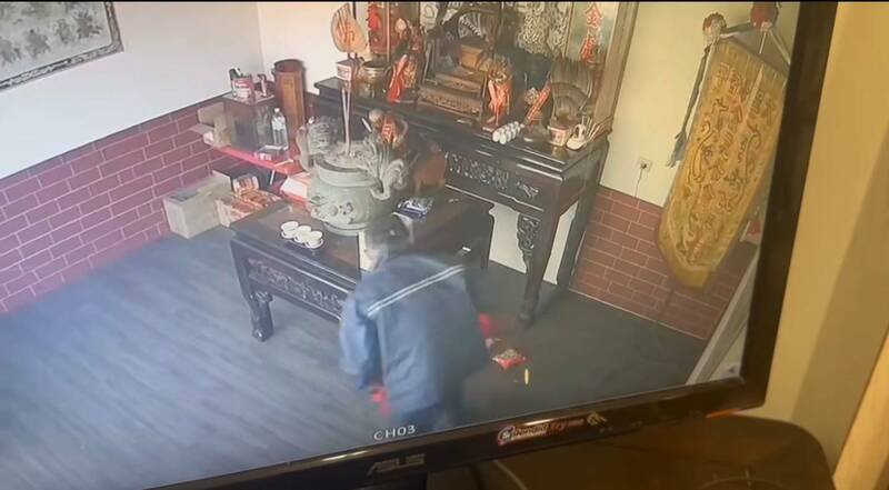 监视画面可见男子爬到神桌上将神明扯到地面，再偷走金牌。（民众提供）