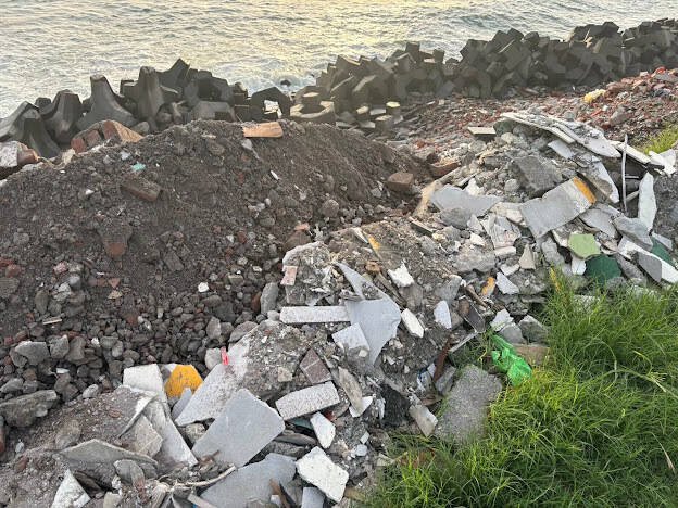 高雄梓官区海岸边坡遭非法倾倒建筑废弃物，2人遭检方起诉。（警方提供）