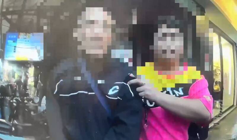 陈男将烟蒂乱弹击中赖姓女骑士，还持雨伞攻击赖女，一旁正义哥见状立即将陈男制伏。（记者陆运锋翻摄）