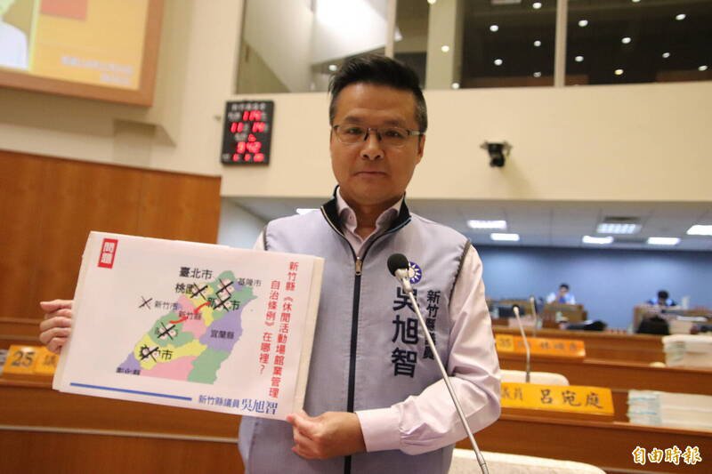 新竹县议员吴旭智手捧新竹县周边各县市严查防堵麻将馆、桌游店可能「假休闲、真赌博」的问题，显得新竹县成了这类店家的「磁吸地」。（记者黄美珠摄）