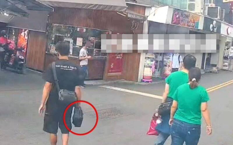 台中1名民众到一中街收废油，却被偷走放在车上的黑色包包和手机，监视器拍到窃嫌手上拿著黑色包包离开的身影。（撷取自社会事新闻影音）