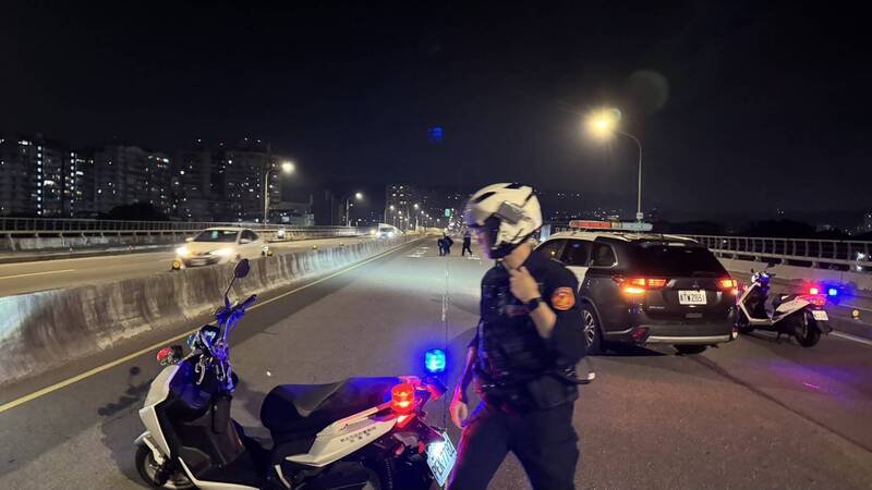 新北市一辆运钞车在板桥浮洲桥上掉落一袋零钱，警方警示封路。（记者吴仁捷翻摄）