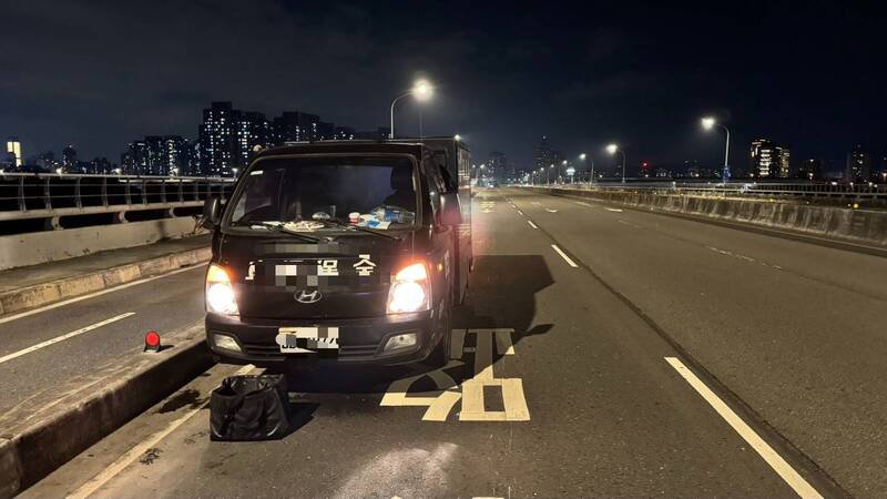 新北市一辆运钞车在板桥浮洲桥上掉落一袋零钱（见图），保全员冒险摸黑捡拾。（记者吴仁捷翻摄）