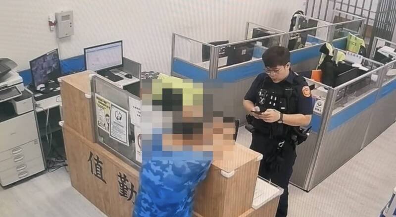 李姓男子涉嫌杀妻后，冷静走进内坜派出所自首，并伸出双手作势希望警方上铐。（记者李容萍翻摄）