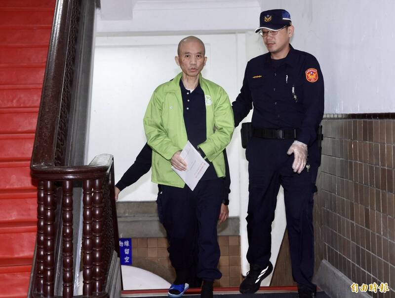 中国香港籍共谍丁小琥，在法警戒护下进入法院应讯。（记者罗沛德摄）