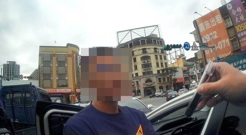 员警敲车窗叫醒开车在路口沉睡、手握毒品的邱姓男子（中）。（桃园市警察局提供）