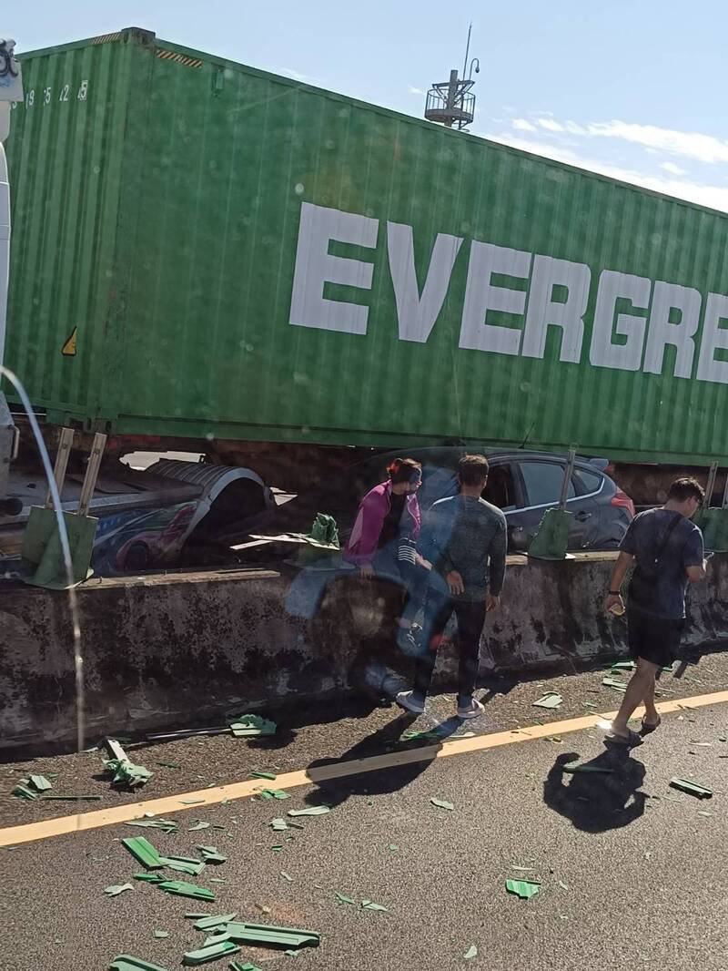 长荣货柜车行经国1中坜路段爆胎擦撞轿车、内侧护栏。（民众提供）