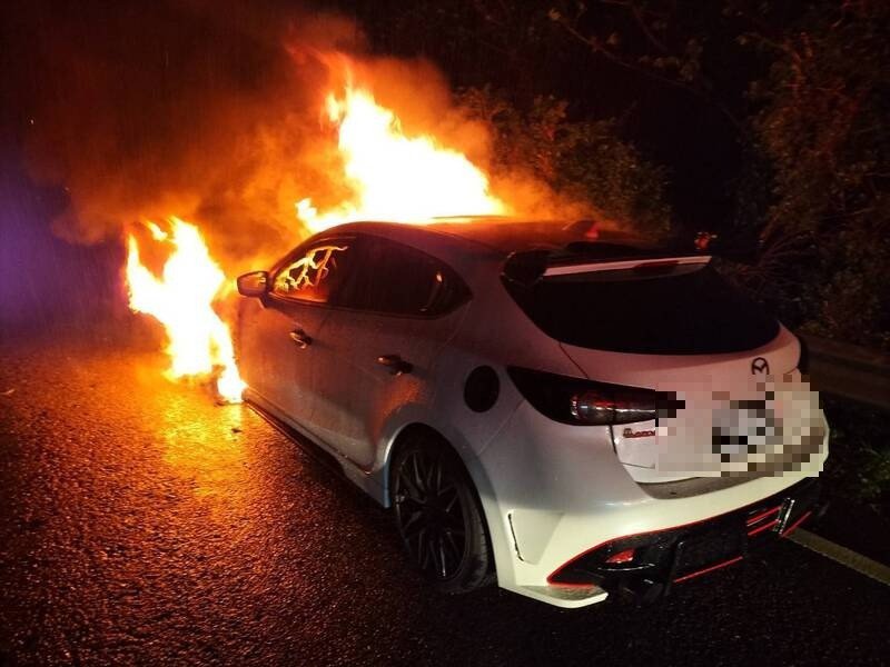 一辆白色轿车晚间8点半行经国道一号南下7.6公里五堵段时，车头突然起火燃烧，基隆市消防队员赶抵迅速灭火，车上包括驾驶等3人均未受伤。（记者林嘉东翻摄）