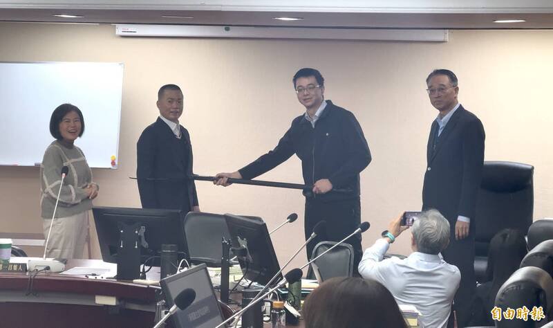 台北市政顾问陈启宏（左二）致赠防暴叉，捷警队长廖洛育（右二）、北捷总经理黄清信（右一）代表接受，左一为交委会第一召集人游淑慧。（记者董冠怡摄）