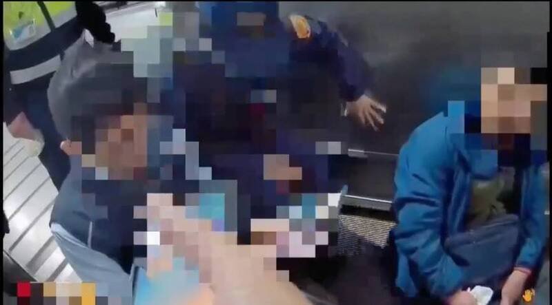 警方（中）和捷运站务人员（左）救援陈男（右）。（记者陈彩玲翻摄）