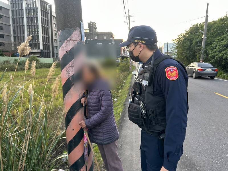 桃园吴姓阿嬷被车流吓到「抱电杆」，平镇警暖送她回家。（警方提供）