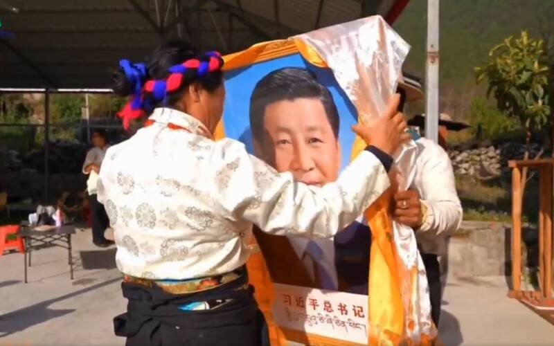 藏民手举「习近平总书记」的相框，还搭衬白布和黄布。（取自萨格尔扎西SakarTashi X 影片）