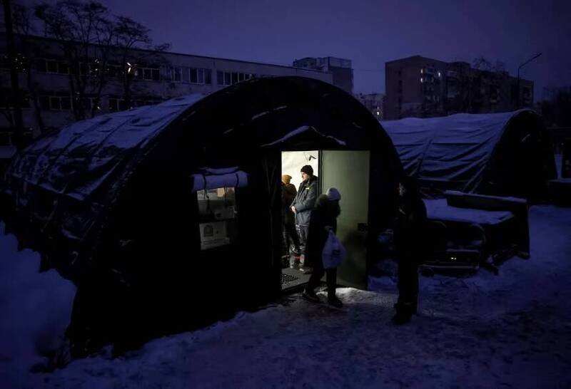 乌克兰基础设施频遭轰炸引发严重能源危机，首都基辅居民在断电期间，前往政府设立的人道援助站领取热食。（路透）