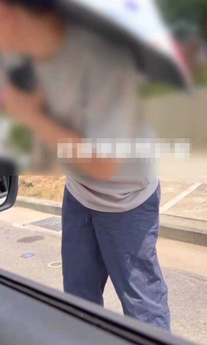 台中一位撑伞民众，昨天在科博馆附近「人肉占车位」，警方强调已违反道交条例可开罚。（撷取自社会事新闻影音）