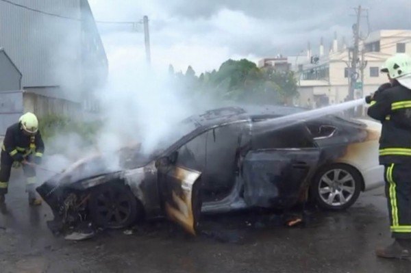 百万进口名车被大火吞噬，消防人员灌救数分钟内将火势扑灭，整辆车烧成废铁。（记者汤世名翻摄）